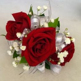 Red roses with white filler flowers and silver ribbon accents