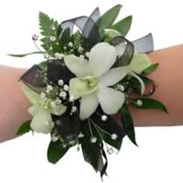 White floral wrist corsage with ribbon and greenery