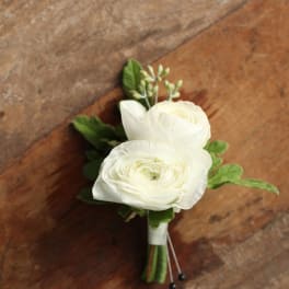 Small white flower boutonniere with green accents