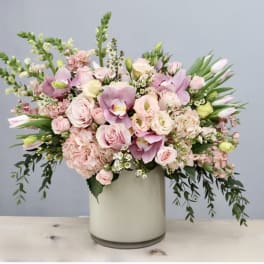 Pink and white floral arrangement in a tall cream vase