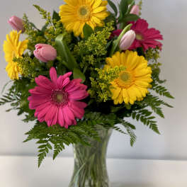 Bouquet of pink and yellow gerbera daisies in a clear glass vase