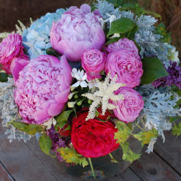 Pink and lavender bouquet with red roses in a glass vase