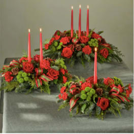 Three red floral candle centerpieces with tall taper candles
