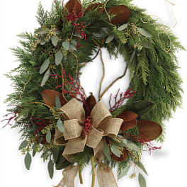 Holiday wreath with evergreen foliage, red berries, and a burlap bow
