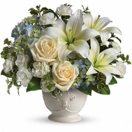 White lilies and cream roses in a decorative vase