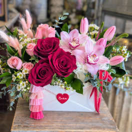Pink and red rose arrangement with orchids in a white box