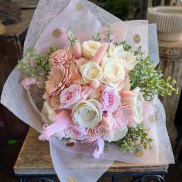 Pink and cream bouquet with roses and daisies wrapped in sheer paper