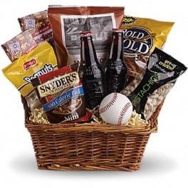 Snack gift basket with bottled drinks, assorted packaged treats, and a baseball in a wicker basket