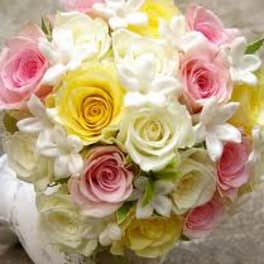 Bouquet of pink, yellow, and white roses with white blossoms