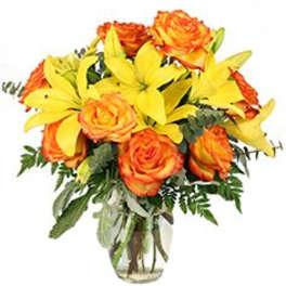 Bouquet of orange roses and yellow lilies in a clear glass vase