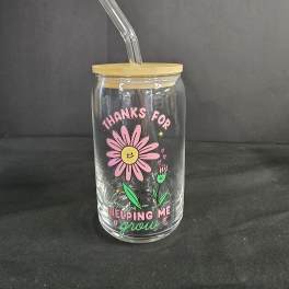 Clear glass tumbler with bamboo lid and straw, decorated with a pink daisy graphic
