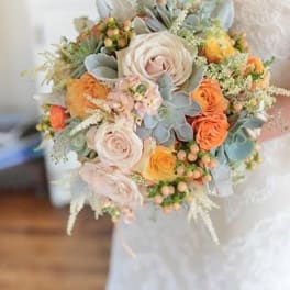 Bridal bouquet with pale roses, orange blooms, and blue-gray succulents