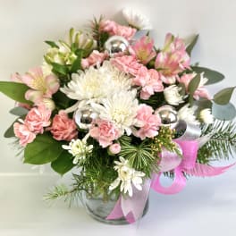 Pink and white bouquet in a glass vase with silver ornaments and ribbon