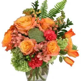 Orange roses and tulips in a glass vase