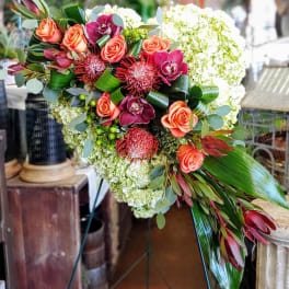 Heart-shaped floral arrangement with coral roses and white blooms
