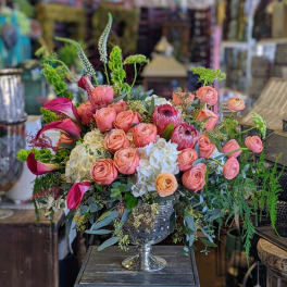 Pink and peach roses in a silver pedestal vase