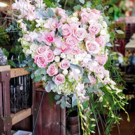 Pink roses and orchids arranged in a large standing display