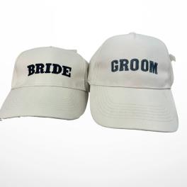 Two white caps labeled BRIDE and GROOM