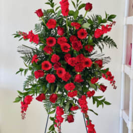 Tall standing spray of red flowers on a metal easel