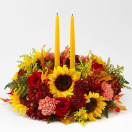 Autumn floral centerpiece with two yellow taper candles