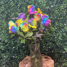 Rainbow-colored roses in a clear glass vase