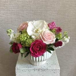 Bouquet of pink and white roses in a white ceramic vase