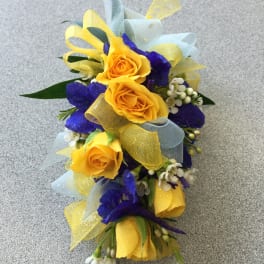 Yellow roses with blue flowers and ribbon in a small bouquet