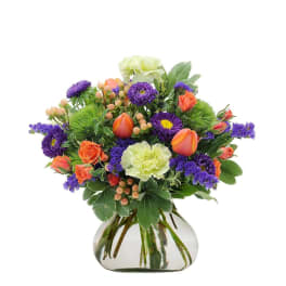 Bouquet of orange and purple flowers in a clear glass vase