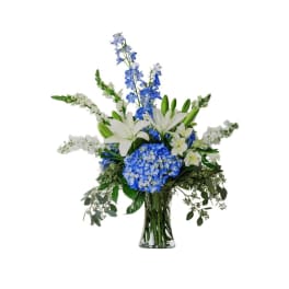 Blue and white floral arrangement in a clear glass vase