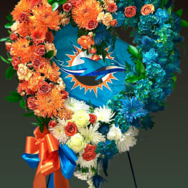 Heart-shaped floral wreath with orange, blue, and white flowers around a Miami Dolphins logo