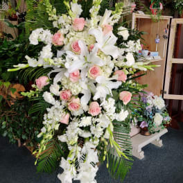 Tall standing floral spray with white lilies, pink roses, and white blooms