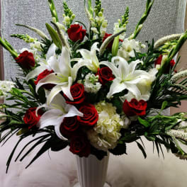 Red roses and white lilies in a tall white vase
