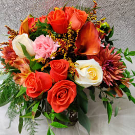 Bouquet of orange and white roses with pink flowers in a vase