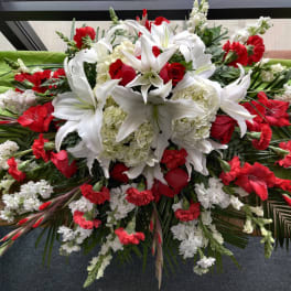 Red and white floral casket spray with lilies and carnations