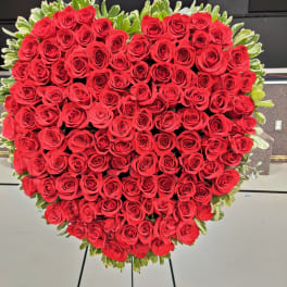 Heart-shaped arrangement of red roses on a stand