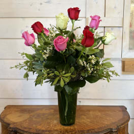 Bouquet of red and pink roses in a tall glass vase