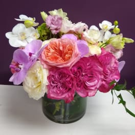 Mixed pink, white, and lavender flowers in a glass vase
