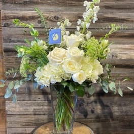 White roses and pale blooms arranged in a clear glass vase