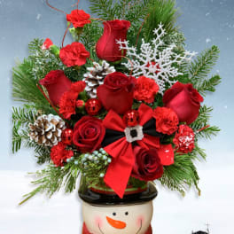 Red roses and carnations in a snowman planter with pinecones and ribbon