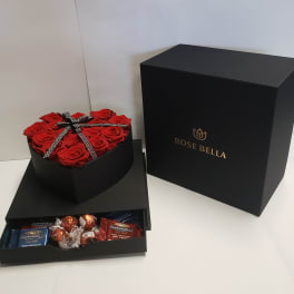 Heart-shaped box of red roses with chocolates in a black gift box