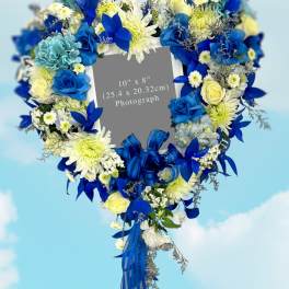Heart-shaped floral wreath with blue and white flowers and ribbon