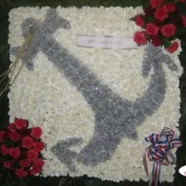 White floral funeral tribute with a gray dove design and red rose clusters