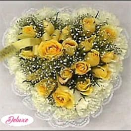 Yellow roses with white baby's breath in a heart-shaped arrangement