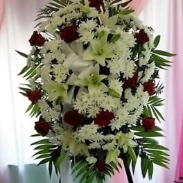 Standing floral spray with white lilies, white daisies, and red roses