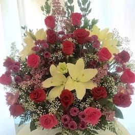 Tall bouquet of red roses and yellow lilies with pink filler flowers