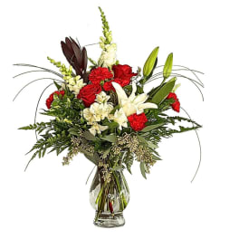 Red roses and white lilies in a clear glass vase