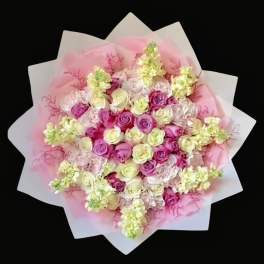 Pink and white rose bouquet wrapped in pale paper