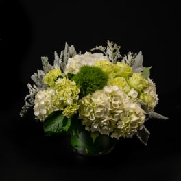 White and green floral arrangement in a glass vase