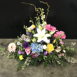Colorful floral arrangement with a white lily, gerbera daisies, and roses