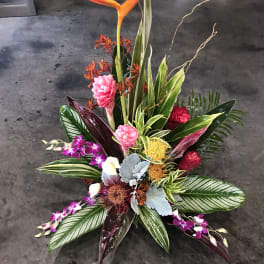 Tropical floral arrangement with orange heliconia and pink orchids